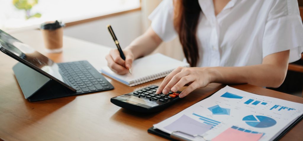 hand business doing finances and calculate on desk about cost us